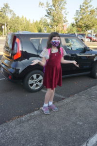 A student gets out of the car on her first day of school